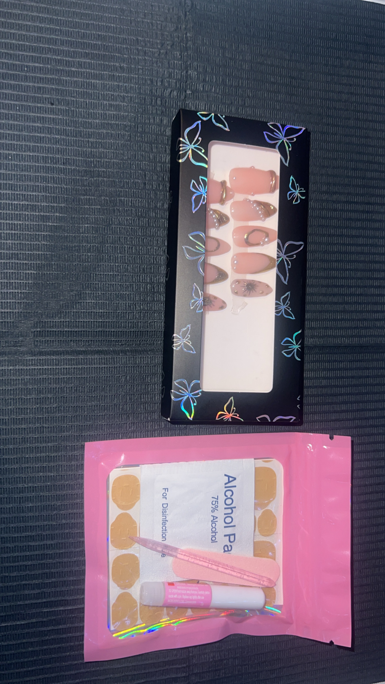Pearl and gold press-on nails in their box with application kit